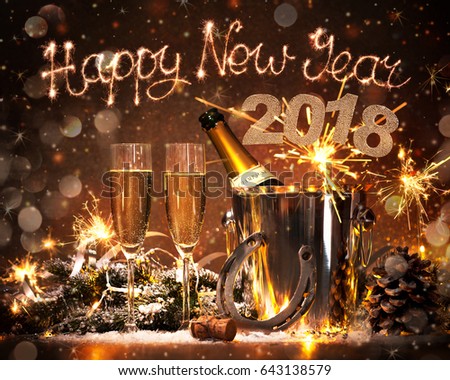 New Years Eve celebration background with pair of flutes and bottle of champagne in bucket and a horseshoe as lucky charm