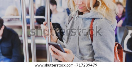 person looking at the screen of smart phone in subway, woman holding mobile in metro