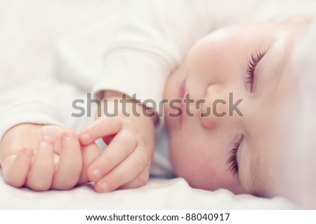 close-up portrait of a beautiful sleeping baby on white