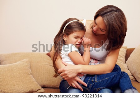 pretty mother soothing and hugging crying baby girl