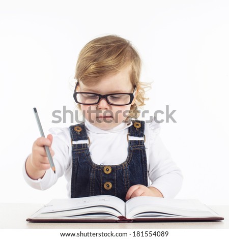 cute happy little girl writing something in her notebook