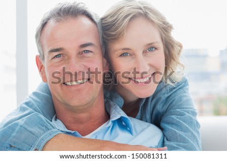 https://thumb7.shutterstock.com/display_pic_with_logo/76219/150081311/stock-photo-smiling-woman-hugging-her-husband-on-the-couch-from-behind-at-home-in-the-living-room-150081311.jpg