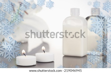 Composite image of snowflake frame against white orchid glass flasks and lighted white candles