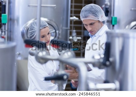 Biologist team talking and wearing hairnet in the factory