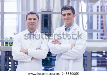 Scientist team smiling at camera with arms crossed in the factory