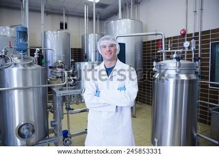 Scientist with arms crossed wearing protective glasses in the factory