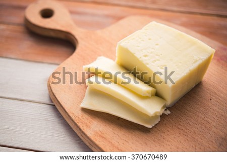 Italian cheese sliced on a wooden board