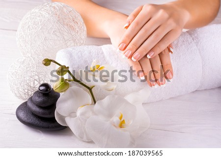 Beautiful hands with manicure and orchid flower