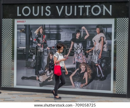 TOKYO, JAPAN - SEPTEMBER 1ST, 2017. Woman walking in front of Louis Vuitton outlet at Tokyo Station.
