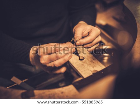 Jeweler at work in jewelery workshop.