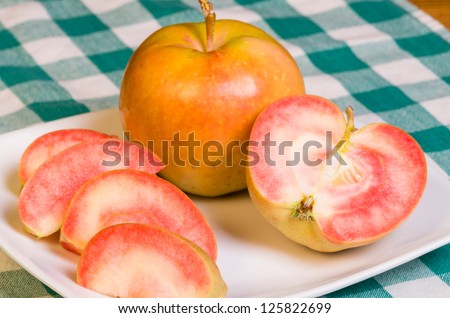 Pink Pearl Apples freshly sliced onto a white plate
