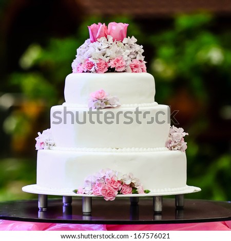 White four tiered wedding cake on table - stock photo