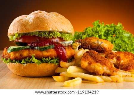 Big hamburger, chicken nuggets and French fries - stock photo