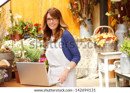 https://thumb7.shutterstock.com/display_pic_with_logo/816064/142694131/stock-photo-smiling-mature-woman-florist-small-business-flower-shop-owner-she-is-using-laptop-to-take-orders-142694131.jpg