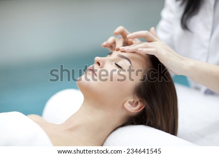 spa, resort, beauty and health concept - beautiful woman in spa salon getting face treatment
