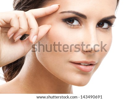 Portrait of happy smiling beautiful young woman touching skin or applying cream, isolated over white background