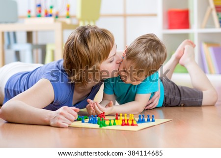 Family Child And Mom Playing Board Game At Home On The Floor Family Child And Mom Playing Board Game At Home On The Floor