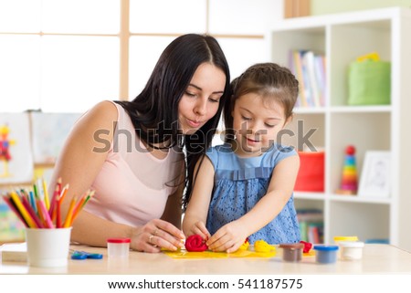 kid girl and mom play with plasticine at home
