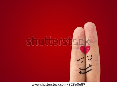 A happy couple in love with painted smiley and hugging