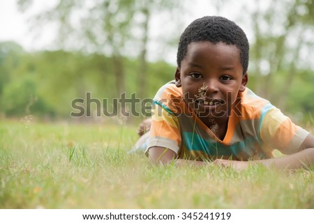 African boy is relacing in the grass