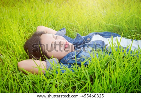 Beautiful asian girl sleeping on grass field