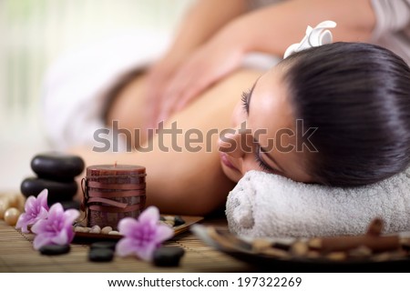 Beautiful woman having a wellness back massage at spa salon