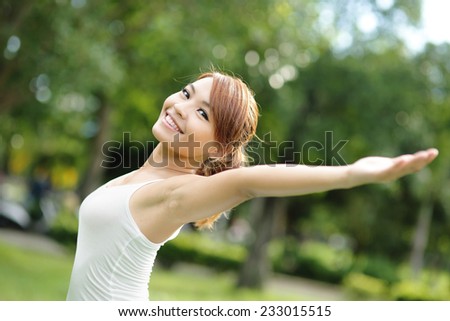 Carefree and free cheering woman in the park. girl raising her arms up smiling happy. asian beauty