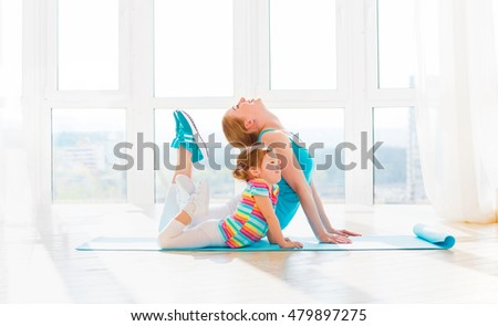 family mother and child daughter are engaged in fitness, yoga, exercise at home