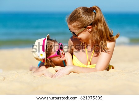 Happy family mother and child daughter for swimming on beach in summer