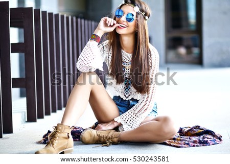Funny stylish sexy smiling beautiful young hippie woman model in summer white hipster clothes posing in the street