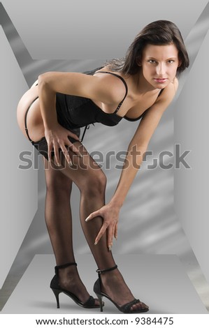 cute and sensual brunette in black lingerie into a gray box