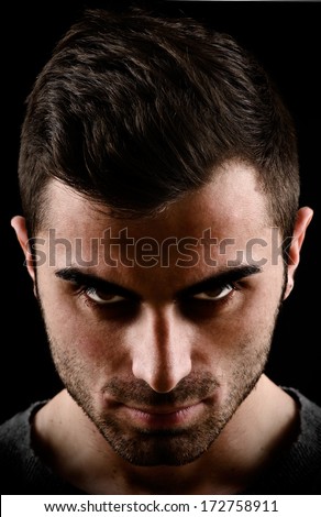 dark portrait of a man with scary eyes - stock photo