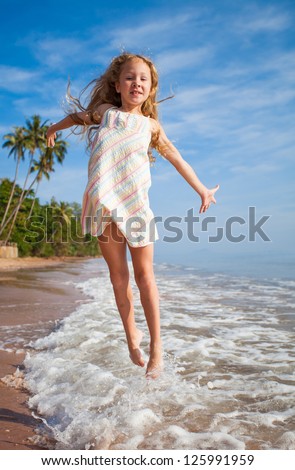 flying jump beach girl on blue sea shore in summer vacation - stock photo