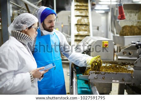 Young food control experts consulting while estimating quality of seaweed salad