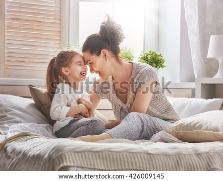 Happy loving family. Mother and her daughter child girl playing and hugging.