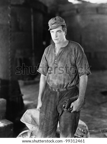 Construction worker standing near a wheelbarrow