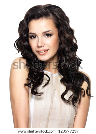 Photo of young woman with beauty long curly hair. Fashion model posing at studio.