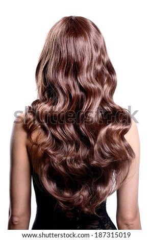 Back view of brunette woman with long black curly hair posing at studio.