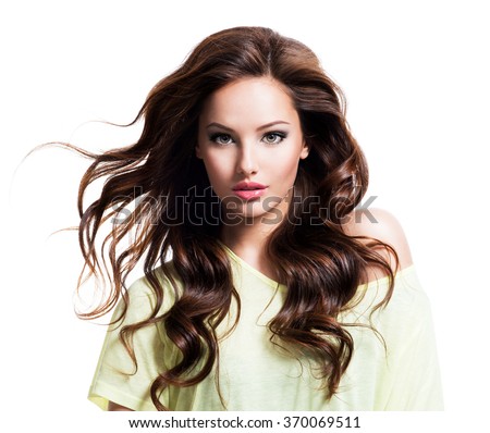 Face of the sensuality beautiful woman with long brown curly hair in yellow shirt