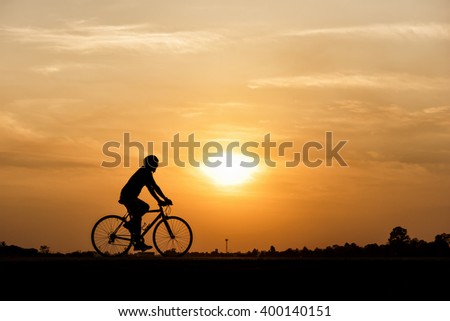 Silhouette of cycling on sunset background