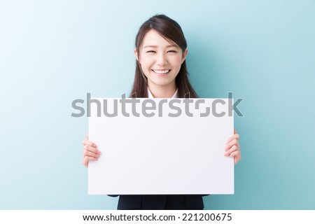 young attractive asian woman holding blank white board