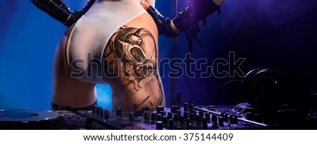 Very nice ass with a tattoo of the girl - DJ, standing near the remote