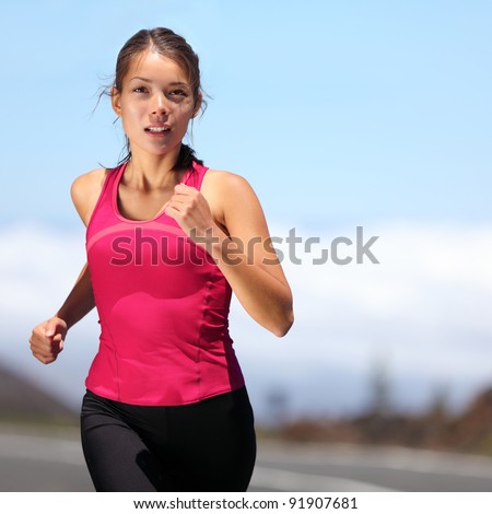 runner - woman running outdoors training for marathon run. Beautiful fit asian fitness model in her 20s.