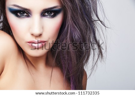 Portrait of beautiful young woman with long colored brown hair and bright make-up