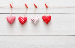 Valentine Background With Sewed Pillow Hearts Row Border On Red Clothespins At Rustic White Wood Planks Valentine Background With Sewed Pillow Hearts Row Border On Red Clothespins At Rustic White Wood Planks