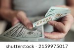 Small photo of dollar money. bankrupt man counting money cash. business crisis finance lifestyle dollar concept. close-up of a hand counting paper dollars. exchange finance economy dollar usd