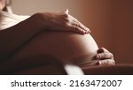 Small photo of pregnant woman. health pregnancy motherhood procreation concept. close-up belly of a pregnant woman. woman waiting for a newborn baby. sunlight pregnant woman holding her belly indoors