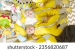 Small photo of sleeping baby twins on a baby bed. happy family child dream concept. The twin baby settled down to sleep in a cozy bed. newborn baby twins lie in a children bed looking at toys lifestyle