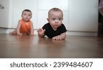Small photo of beautiful twin baby crawling. carefree twins childhood. baby a boy funny crawling on the pope on the floor learning to crawl. Portrait twin of colorful baby lifestyle crawling