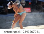 Small photo of GSTAAD, SWITZERLAND - JULY 9, 2023: Professional beach volleyball player Kristen Nuss (USA) spraying sun body spray on her legs during the Volleyball World Beach Pro Tour event at Gstaad.